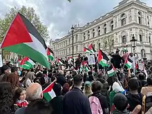 A dense protest with many Palestinian flags flying.