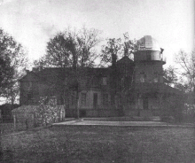 Black and white photo of a two-storey mansion with an astronomer's observatory on the roof
