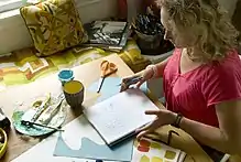 Woman sitting at a desk with a sketchbook