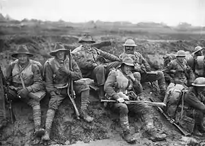 Australian soldiers at the front during World War I. Some are wearing slouch hats, steel helmets, sheepskin jackets and woollen gloves, demonstrating both the variety of official battledress, and how it was modified and augmented, for local conditions.