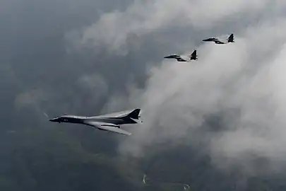 (A U.S. Air Force B-1B Lancer, deployed to Andersen Air Base, Guam, is flanked by two F-15K Slam Eagles)