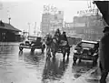 A dray, a Ford and a Morris Oxford Roadster, both 1932 models, in summer rain, Railway Square, Sydney, Jan 1935