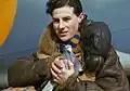 A member of the crew of an RAF Coastal Command Lockheed Hudson holding a carrier pigeon, 1942