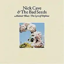 A photograph of a series of flowers in part of an arc are surrounded by a cream coloured border. Black text above the photograph reads "Nick Cave & The Bad Seeds" and italicised black text reads "Abattoir Blues / The Lyre of Orpheus".