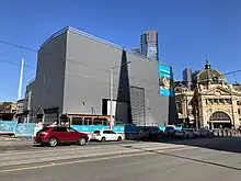 Acoustic box over the Federation Square entrance to Town Hall station, with Flinders Street station in the background.