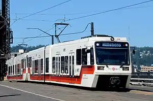 Top: A MAX train and a Portland Streetcar tram traversing Tilikum CrossingBottom: A westbound Type 2 Blue Line train crossing the Steel Bridge