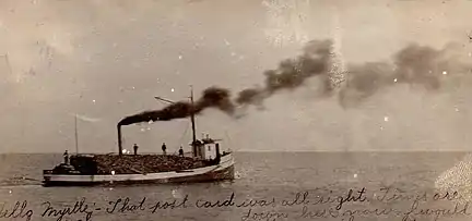 The steam barge Addie Wade outbound from Jacksonport with a with cargo of logs; from a postcard postmarked in 1906