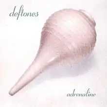 A picture of a pastel pink bulb syringe with the band logo and album title in blue.