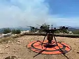 An unmanned aerial vehicle (UAV) ready to conduct aerial ignitions to control the fire