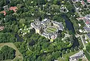 Aerial view of Bückeburg Palace: On the left is the old Renaissance building, with a tower grouped around an inner courtyard. The neo-baroque extension consists of a wing on the right and two separate wing buildings in front. The old moat still runs around the complex, but without the former defensive ramps.