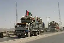 Afghan refugees returning from Pakistan with an Afghan tricolor flag on their truck (2004)