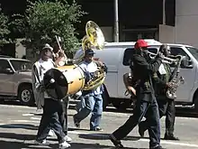Three members of the Rebirth Brass Band and other musicians play for a second-line parade in the Central Business District of New Orleans in 2007.