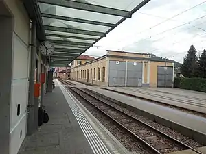 Double-track railway line with side platform and vehicle depot at right