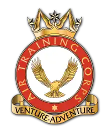 A heraldic badge of the Air Training Corps. Its motto, 'Venture Adventure' is contained in a stylised scroll at the foot of the badge.