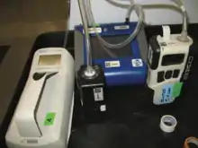 Four small pieces of machinery connected by clear tubes sitting on a table