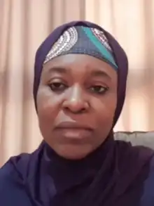 Yesufu, pictured from the shoulders up wearing a purple hijab and patterned underscarf