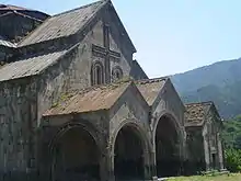 Gabled roof with extensions over a covered entrance with two gabled arches.