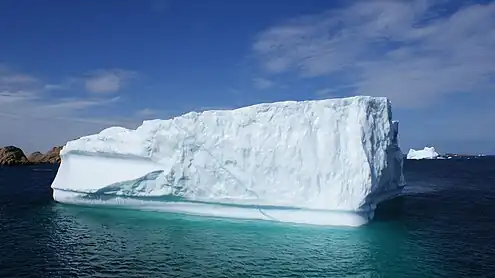 An iceberg floating at the mouth of the fjord; southern end