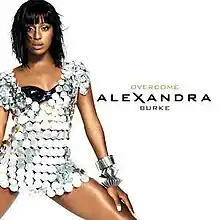 Image showing a young woman wearing a short silver sparkly dress on white background. The words "Alexandra Burke" and "Overcome" are written to the right of the woman.