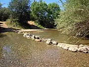 Stepping stone crossing next to a fording point on the river