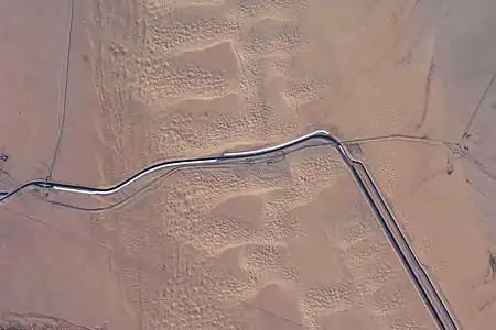 This image captures about 15 kilometers (9.3 mi) of the All-American Canal just west of Yuma, Arizona. The photo is taken of the southern section of the Algodones Dunes.