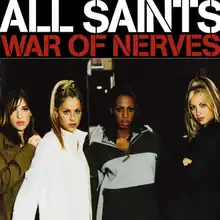 A portrait of All Saints dressed in jackets, standing next to each other in a dark corridor.