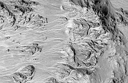 Alluvial Fans in Mojave, as seen by HiRISE. The crater rim is on the right. A branched network of channels runs down towards the left.