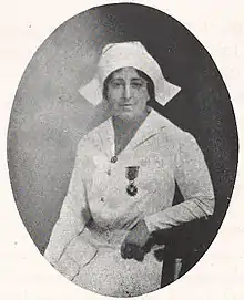 A white woman with dark hair, wearing a nurse's uniform and cap, with a medal pinned to the chest; in an oval frame.