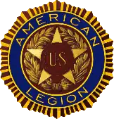 Five-pointed star with the insignia "U. S." enclosed in two bronze bands in the star's center. This design is enclosed in a wreath. Encircling the star and the wreath are the words "American Legion" set in deep blue enamel. This, in turn, is encircled by a narrow band suggestive of the rays of the sun