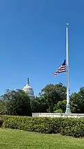 An American flag at half-staff at the Supreme Court, which is not shown while the US Capitol can be seen in the background.