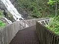 An observation bridge spans across the waterfall