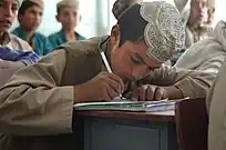 Photo of a boy taking notes at school