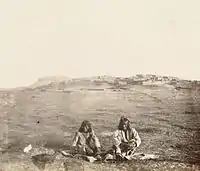 Zuni men and the ancient Pueblo Town of Zuni, c. 1868