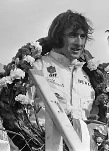 Jackie Stewart wearing a laurel reef around his neck in celebrating a race victory