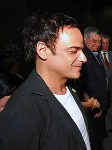 Ângelo Antônio Carneiro Lopes wearing dark suit jacket, seen from profile, smiling