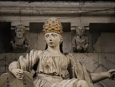 Baroque sculpture and earlier modillons behind her in the choir