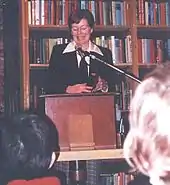 Bannon in a bookstore at a podium reading in front of an audience