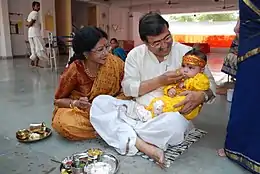 Image 10Samskaras are, in one context, the diverse rites of passage of a human being from conception to cremation, signifying milestones in an individual's journey of life in Hinduism. Above is annaprashana samskara celebrating a baby's first taste of solid food. (from Samskara (rite of passage))