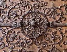 Wrought-iron spreading scrolls with flowers on a door of Notre Dame de Paris.