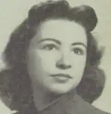 A young white woman with dark curly hair and dark eyes