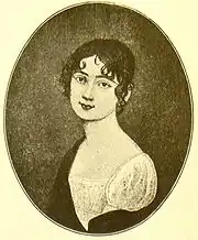 Black and white upper body portrait of a young woman with short, dark hair, wearing a simple white dress.