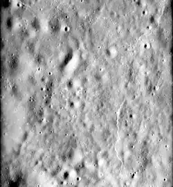 The floor of Mandelʹshtam, showing a typical highlands scarp at right.  From Apollo 16.