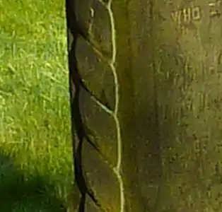 A border of plied yarn around the monument indicates that the family worked in the wool trade