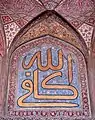 Arabic calligraphy on glazed tile: "God is aplenty".