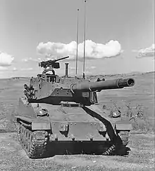 A black and white photo of an AGS that sits in an open field. An M2 Browning machine gun is mounted at the commander's station.