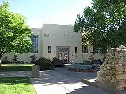 The Art Annex (1926) at UNM, a more abstract Pueblo style building, evokes vigas using stylized ornamentation