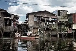 A family rows across the flooded 'streets' of Artex Compound