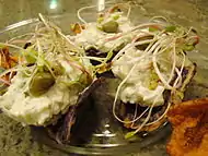 Crisps topped with artichoke dip and sprouts