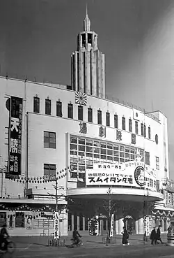 A large theater building with Japanese language signs on it.