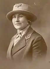 Jacketed neat Woman in portrait wearing a western style hat with YMCA on it